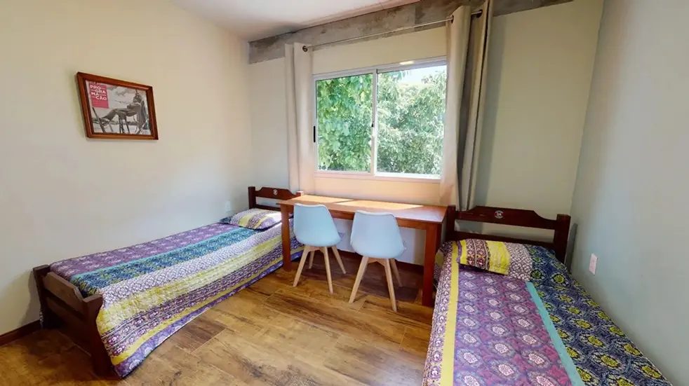 Habitación con dos camas y escritorio en la Residencia Universitaria Vintage
